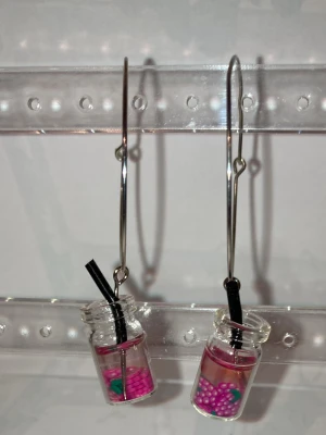 Örhängen  -  Handgjorda örhängen som görs av mig. Med lila frukter i ett glas. Frakten är ca 22-100kr beroende på vikten på produkten . Kontakta mig om du vill köpa.