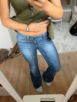 Blå bootcut jeans från Esprit - Säljer ett par snygga blå bootcut jeans från Esprit. De har låg midja, klassisk femficksdesign och är gjorda i jeansmaterial. Färgen är mellanblå med lätt slitning för en cool look. 