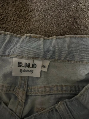 Ljusblå jeans från D.M.D by denim day - Säljer ett par ljusblå jeans från D.M.D by denim day i storlek 146. Klassisk femficksmodell med raka ben och resår i midjan. Perfekta för dig som gillar en enkel och clean look. Passar till det mesta och är riktigt sköna att bära.