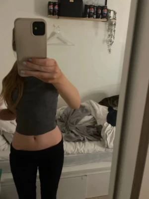 Mörkgrå croppad topp från Monki - Säljer en enkel och stilren mörkgrå croppad topp från hm. Toppen har rund halsringning och korta ärmar. Perfekt till jeans eller kjol för en clean look. Materialet är mjukt och stretchigt, troligtvis bomull eller en bomullsblandning.