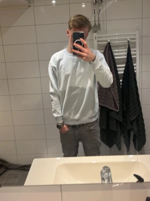 Ljusblå sweatshirt från Tommy Hilfiger - Säljer en stilren ljusblå sweatshirt från Tommy Hilfiger med klassisk logga broderad på bröstet. Tröjan har rund halsringning med ribbade muddar och är långärmad. Perfekt för dig som gillar enkel och snygg streetstil.