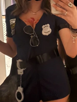 Mörkblå polis klänning, bälte, hatt - En polis klänning med shorts insydda, perfekt till halloween! Tillhör bältet, hatten som på bilden