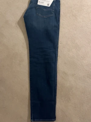 Replay Hyperflex Anbass blå jeans - Säljer ett par Replay Hyperflex Anbass jeans i klassisk blå tvätt. Jeansen har fem fickor, normal passform och raka ben. Materialet är stretchigt jeans-tyg som ger extra komfort. Snygga kontrastsömmar och Replay-lapp bak i midjan. Perfekta för dig som vill ha stilrena och bekväma jeans. ‼️Storlek w31 l32, HELT NYA‼️