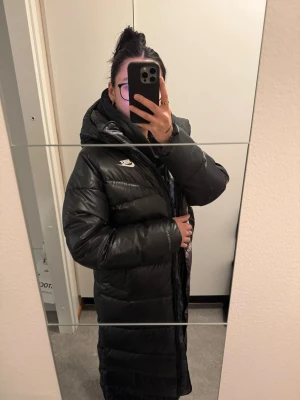 Nike Sportswear City Parka - Nike dunkappa med avtagbar kapuschong. Sparsamt använd 2 säsonger. Inga synliga slitage och fri från fläckar. Nypris: 3395kr