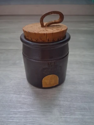 Höganäs Keramik burk/krus med korklock  - Säljer denna lilla burk/krus 1/4L från Höganäs keramik. Höjd med lock ca 8cm diameter kant till kant ca 7cm. Perfekt att förvara småsaker i eller bara ha som en prydnad 