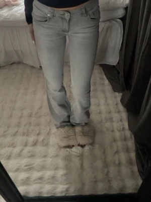 Ljusgrå bootcut jeans från lager 157 - Säljer ett par ljusgrå jeans från lager 157 i storlek S. De har bootcut-modell med låg midja och klassiska fem fickor. Jeansen är i mjukt denimtyg och har en snygg, enkel look som passar till det mesta. Perfekta om du gillar en relaxed men ändå trendig stil.
