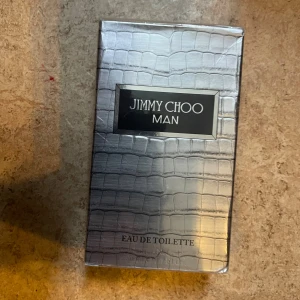 Jimmy Choo Man Eau de Toilette - Stilren och modern herrparfym från Jimmy Choo. Snygg förpackning med silvermönster. Perfekt för dig som vill sticka ut med en ikonisk doft. Tillverkad i Paris.