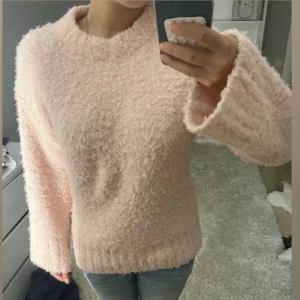 Ljusrosa fluffig tröja från Divided XS - Supermysig ljusrosa fluffig tröja från Divided i storlek XS. Tröjan har långärmade, lite bredare ärmar och är tillverkad i 100% polyester. Perfekt för dig som gillar en cozy och chill vibe. Rund hals och ribbad nederkant för extra comfy känsla.