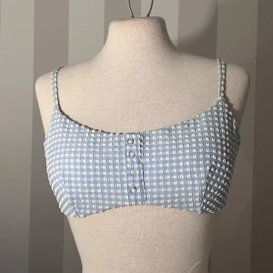 Blåvit rutig bikini med knyt - Supersöt bikini i blåvitt rutigt mönster med smala axelband och knyt i ryggen.