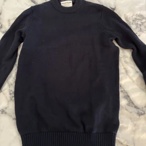 Mörkblå stickad tröja Bruun & Stengade - Snygg mörkblå stickad tröja från Bruun & Stengade i storlek S. Tröjan har rund hals med ribbad kant och långa ärmar. Perfekt för dig som gillar klassisk stil med enkel design och mjukt material. Tröjan är i nyskick då jag aldrig använt den!