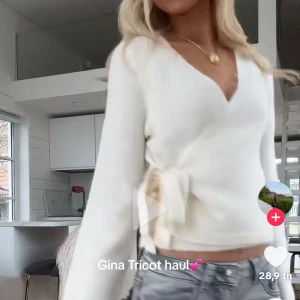 Vit omlottkofta från Gina Tricot - Superfin vit omlottkofta från Gina Tricot med knyt i sidan och v-ringad hals. Koftan är stickad och har långa ärmar, perfekt att slänga på sig till jeans. Mjuk och skön känsla, passar till både chill och snygga outfits.