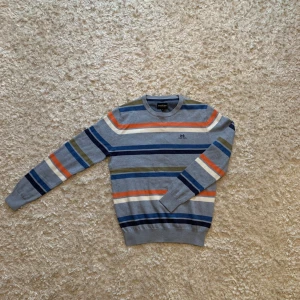 Grå tunt stickad randig tröja från Jean Paul - Säljer en snygg randig tröja från Jean Paul i storlek S. Den är tunt stickad och grå med ränder i marinblått, orange, olivgrönt, vitt och mörkblått. Tveka inte på o skriva vid frågor!