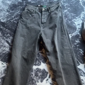 Grå jeans från Jack & Jones - Säljer ett par grå jeans från Jack & Jones med klassisk femficksdesign och raka ben. Jeansen har normal passform och är tillverkade i slitstarkt denimtyg. Perfekta för dig som gillar en enkel och stilren look.