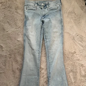 Ljusblå bootcut jeans - Säljer ett par ljusblå jeans med bootcut-modell från H&M. Väldigt snygga och coola som saknar bakficka. Står 164 men skulle säga att de passar XS också!