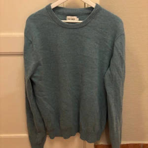 Stickad tröja - Säljer denna snygga stickade tröja från east west i en riktigt snygg färg. Tröjan har inga defekter och är i väldigt bra skick. Den är i storlek L men skulle säga att den sitter mer som M.