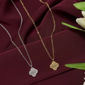 Tålamod halsband med fyrklöverberlock i guld och silver - Snygga halsband med fyrklöverformad berlock i antingen guld- eller silverfärg. Berlocken har ett detaljerat, graverat tålamod ord på arabiska ”Sabr ” som ger en unik och trendig look. Kedjan är tunn och elegant, perfekt för att lyfta din outfit med en stilren touch. Dessa halsband rostar inte, eftersom det är stainless steel, har själv använt dessa i 2 år utan att dem har rostat:)