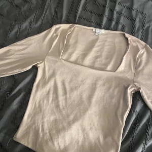 Enkel topp - En enkel beige aktig topp med en fyrkantig form runt halsen och perfekt för vardagen