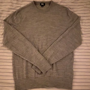 Grå merinoulltröja från Uniqlo XS - Säljer en stilren grå tröja från Uniqlo i mjuk merinoull. Klassisk rund halsringning och långärmad modell som passar perfekt till lager-på-lager. Enkel och clean look som funkar till det mesta. Endast använd 1 gång