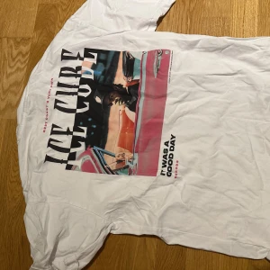 Vit Ice Cube t-shirt med tryck - Vit t-shirt med stort färgglatt tryck på ryggen av Ice Cube i bil och texten 'It Was A Good Day'. Framsidan har en mindre text. Klassisk passform och rund hals. Perfekt för dig som gillar hiphop och streetstyle.