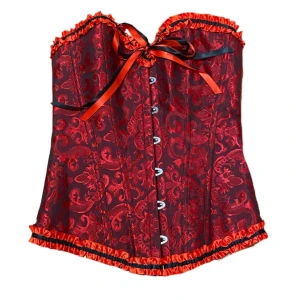 Röd korsett med svarta detaljer - Snygg röd korsett med svart mönster och dekorativa svarta och röda band. Toppen har snörning i ryggen. Perfekt till halloween! Strl S