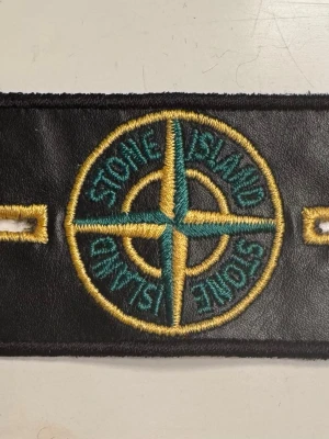 Ny Svart Stone Island badge - Svart Stone Island badge med broderad logotyp. Perfekt för att anpassa dina kläder. Ny! Ca 9x4,5cm. Kan hämtas på Hägerstensåsen eller skickas. 
