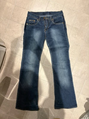 Vintage blå bootcut jeans - Vintage jeans med bootcut passform! På jeansen finns märket Dolce & Gabbana men de är ej akta, däremot är de fortfarande väldigt snygga! Det står ingen storlek i byxorna men passar som en S! Jag är öppen att mäta jeansen så det är bara att meddela mig.