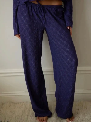 Mörkblå loungewear-byxor i spets - Mörkblå loungewear-byxor med breda ben från Nelly. Går inte att köpa längre. Byxorna är gjorda i ett mjukt, spetsliknande material med diskret mönster.🌴