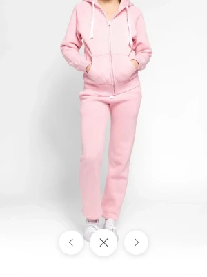 Ljusrosa mjukisbyxor från russemerch set både byxorna och tröjan   - BYXORNA ÄR I STORLEK XS. TRÄJAN ÄR I S. Används få tal gånger, inte min smak med rosa Säljer ett par ljusrosa mjukisbyxor med normal passform och rak siluett. Byxorna har resår i midjan och är perfekta för chill dagar eller när du vill vara extra bekväm. Tillverkade i mjukt bomullsmaterial.