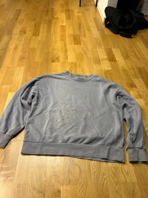 Ljusblå oversized sweatshirt - En enkel och stilren ljusblå sweatshirt med rund hals och breda muddar vid ärmslut och nederkant. Oanvänd.