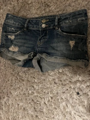 Mörkblå jeansshorts low waist från tally weijl - Säljer ett par mörkblå jeansshorts från Tally Weijl. Low waist-modell med slitningar och dubbelknapp i midjan. Superfin passform och perfekta till sommaren 💙 Använda fåtal gånger, mycketbra skick.