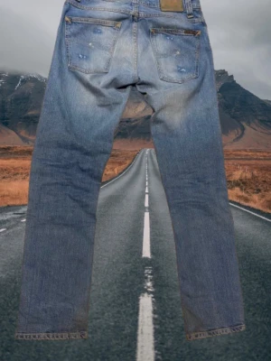 nudie jeans blå - Klassiska blå nudie jeans med raka ben och slitningar.  modell grim tim. storlek 31/32