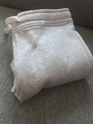 Ljusgrå mjukisbyxor med snörning - Säljer ett par ljusgrå mjukisbyxor med snörning i midjan och en bakficka. Perfekta för chill dagar hemma eller när du vill vara bekväm. Tillverkade i mjukt bomullsmaterial som känns skönt mot huden.💕