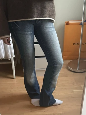 Blåa jeans  - Snygga blå bootcut jeans med slitningar och tvättade detaljer på både fram- och baksida. Normal passform. Är för liten i midjan och passar en yngre person! 