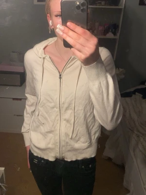 Vit hoodie med dragkedja - Säljer en stilren vit hoodie från 157 i storlek M. Hoodien har dragkedja framtill, huva med snören och ribbade muddar vid ärmslut och nederkant. Perfekt för en avslappnad och trendig look.
