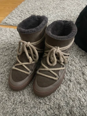 Bruna(taupe) inuikii med snörning - Säljer ett par bruna( färgen heter taupe på hemsidan) inuikii med grova beige snören och mjukt, fluffigt foder.  Perfekta för kalla dagar och riktigt sköna att ha på sig.