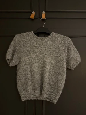 Grå stickad t-shirt från Gina Tricot - Kortärmad stickad t-shirt från Gina tricot som inte används längre. Bra skick