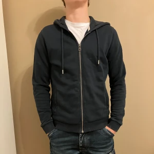 Colmar Tröja Mörkblå - Mörkblå tröja med dragkedja från Colmar.- Ny pris: 1300 kr - Vårt Pris: 400 Kr - Storlek: XS - Längd på Personen: 175 cm. - Först till Kvarn!