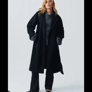 Svart lång kappa gina tricot - Så snygg helt ny svart kappa från gina den va slutsåld hela föra hösten och vintern. aldrig använd. 