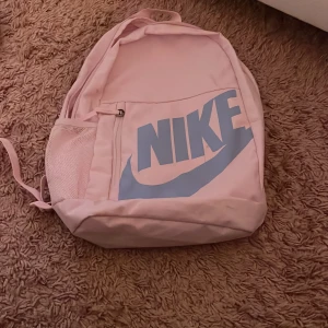 Rosa ryggsäck från Nike - Snygg ljusrosa ryggsäck från Nike och som ni ser har den smutsfläckar som nog går bort 💓💓