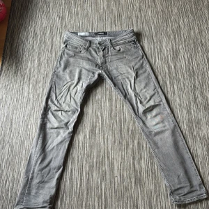 Replay Rocco grå jeans, storlek 31 - Snygga grå jeans från Replay, modell Rocco 573 BIO med comfort fit. Klassisk femficksdesign och raka ben. Jeansen har en cool, lite tvättad look och är gjorda i mjukt jeanstyg som sitter skönt hela dagen.