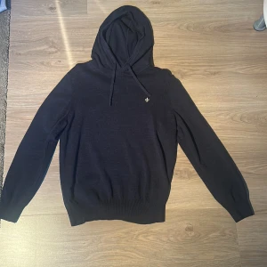 Mörkblå hoodie från Morris - Snygg mörkblå hoodie från Morris. Klassisk modell med huva och dragsko, samt diskret Morris-logga på bröstet. Tröjan är i nyskick och är aldrig använd. Nypris: 2000kr 
