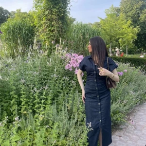 Svart långklänning med knappar - Säljer en svart långklänning med korta ärmar och knappar hela vägen framtill. Klänningen har en snygg slits nertill och markerad midja. Perfekt för dig som gillar stilrena och tidlösa plagg. Materialet känns som bomull. HELT NY ANVÄNDE EN GÅNG!❤️