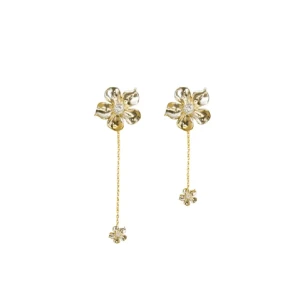 Guldiga blommiga örhängen med kedja från ioaku - Supersnygga örhängen i guld med blommig design och glittrande detalj i mitten. De har en tunn kedja som hänger ner och avslutas med en mindre blomma. Perfekta för dig som vill ha något unikt och trendigt. Har ersatt en plupp.