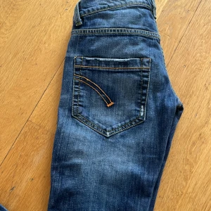 Blå jeans med raka ben - Säljer ett par klassiska blå jeans med raka ben och snygga slitningar. Jeansen har fem fickor, kontrastsömmar och detaljer i kopparfärg. Perfekta för en avslappnad stil och passar till det mesta. Materialet är robust denim.