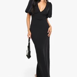 Svart långklänning med v-ringning - Elegant svart långklänning med djup v-ringning och korta, vida ärmar. Klänningen har en figurnära passform och är tillverkad i ett mjukt, följsamt material som ger en snygg siluett. Perfekt för dig som vill ha en stilren och sofistikerad look.