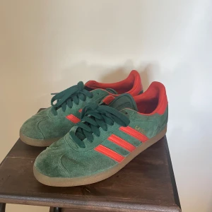 Adidas Gazelle sneakers  - Adidas Gazelle i grön och orange, mockan har blivit lite förmörkad på vissa ställen. Storlek 39 1/3