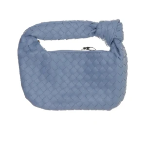 Blå axelväska med flätad design - Snygg blå axelväska med unik flätad struktur och knutdetalj på handtaget. Väskan har en mjuk, rundad form och stängs med dragkedja. Perfekt storlek för det viktigaste och ger en cool touch till din outfit. Bottega Venetta stil, men inte äkta. 