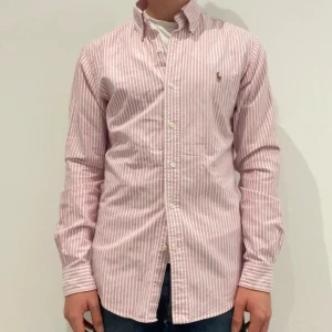 Rosa och vit randig Ralph Lauren skjorta  - Rosa/ vit randig Ralph lauren skjorta || Storlek S (Slim fit) || Skjortan är i bra skick || modellen på bilden är 170cm och väger 62kg || Tveka inte på att höra av dig vid frågor eller funderingar 