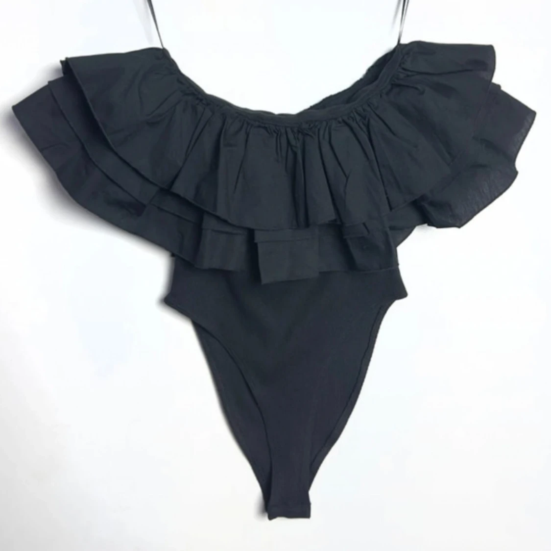 Svart body med volangdetaljer