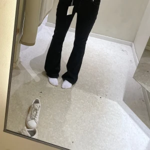 Svarta low flare jeans med bootcut - Säljer ett par svarta jeans med låg midja och bootcut/flare passform. Byxorna har klassisk femficksdesign, dragkedja och knapp framtill. Materialet är jeans och färgen är helsvart, vilket gör dem enkla att matcha med olika stilar.  Inga defekter bara ytterst lite slitna längst ner. Skriv för mått eller fler bilder❤️